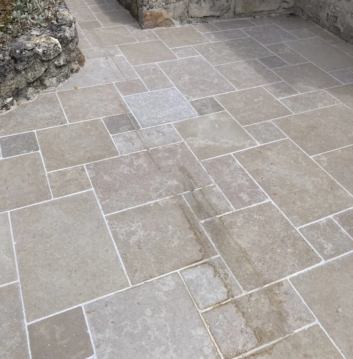 Terrasse extérieure pavée en pierres naturelles calcaires, motif opus romain irrégulier