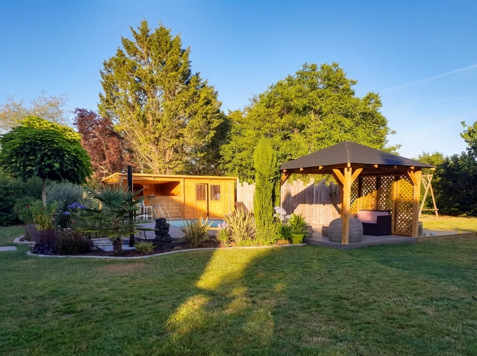 Jardin paysagé avec gazebo en bois traité autoclave à toit en croupe, mobilier de jardin en résine tressée