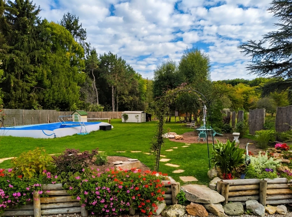 Aménagement paysager d'un jardin résidentiel avec pelouse fraîchement installée, massifs plantés de végétaux d'ornement et paillis sombre